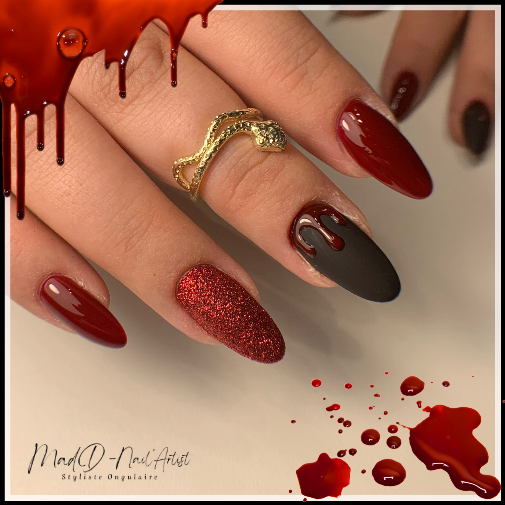 Manucure rouge foncé et noir mat avec nail art gouttes rouges façon effet sang et ongle pailleté rouge.