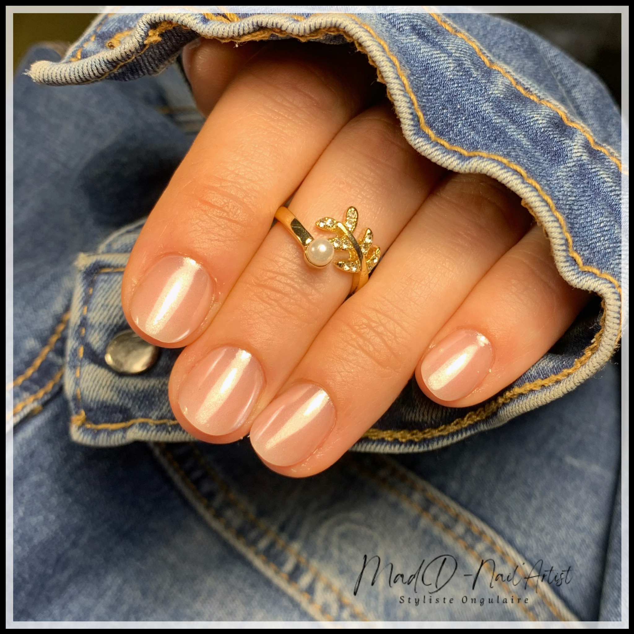 Manucure courte naturelle avec gel nude irisé aux reflets rosés.