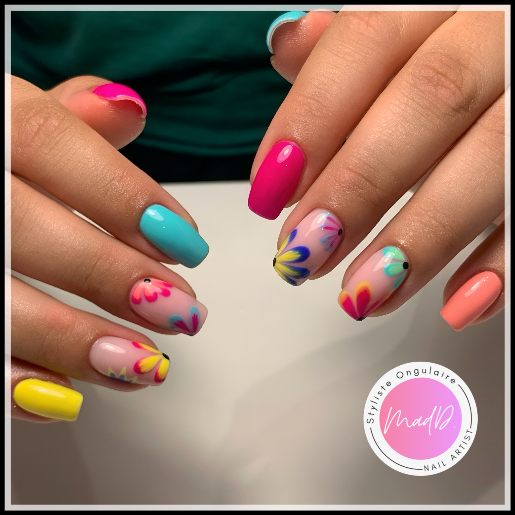 Manucure colorée aux tons rose, bleu, jaune, corail et turquoise avec nail art fleurs pop multicolores.